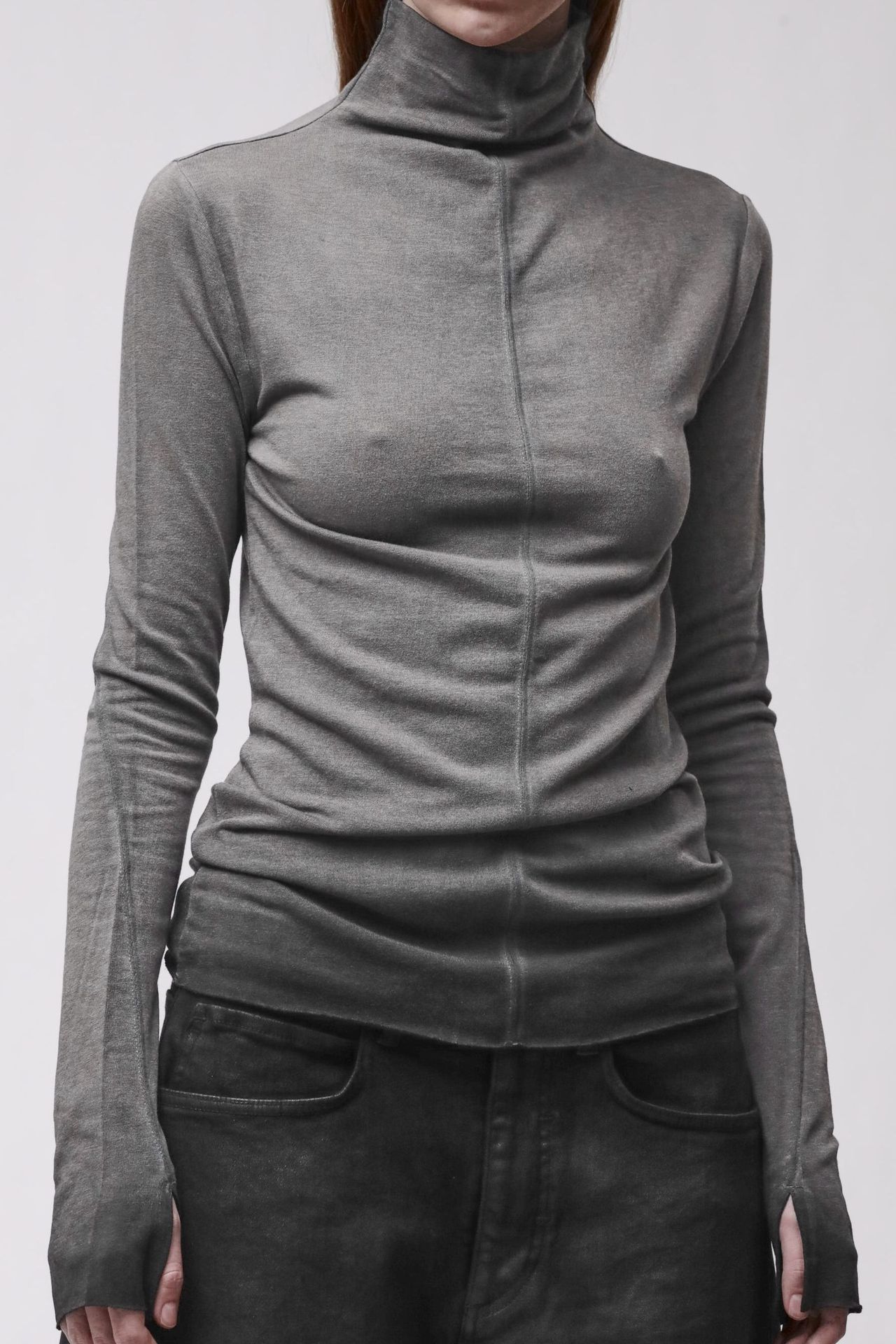 Frau trägt grauen oversized Turtleneck-Pullover mit schwarzen, weiten Jogginghosen.