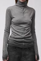 Frau trägt grauen oversized Turtleneck-Pullover mit schwarzen, weiten Jogginghosen.