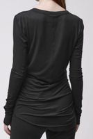 Schwarzes oversized Langarm-Shirt mit weitem Ausschnitt, hinten geknotet, kombiniert mit schwarzen Leggings.