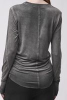 Graue langärmlige Tunika mit weitem Schnitt, hinten mit geradem Rückenausschnitt, kombiniert mit schwarzen Leggings.