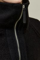 Frau trägt schwarzen Futterjacken-Pullover mit Reißverschluss, seriös-elegant.