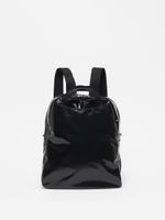 Schwarzer glänzender Rucksack mit schwarzen Trägern, kompakt und mit Reißverschluss.