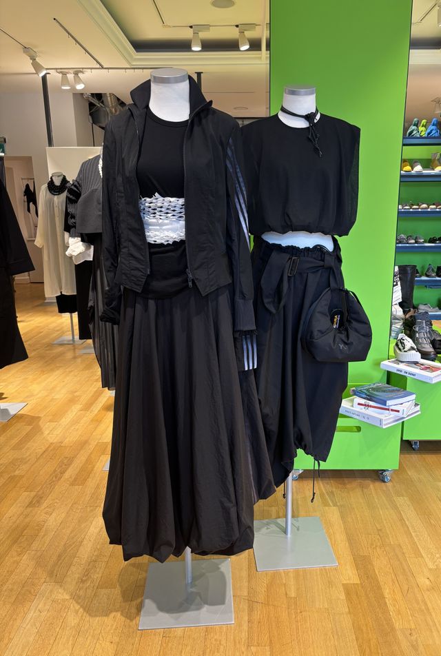 Zwei elegante schwarze Abendkleider auf Mannequins in Boutique.