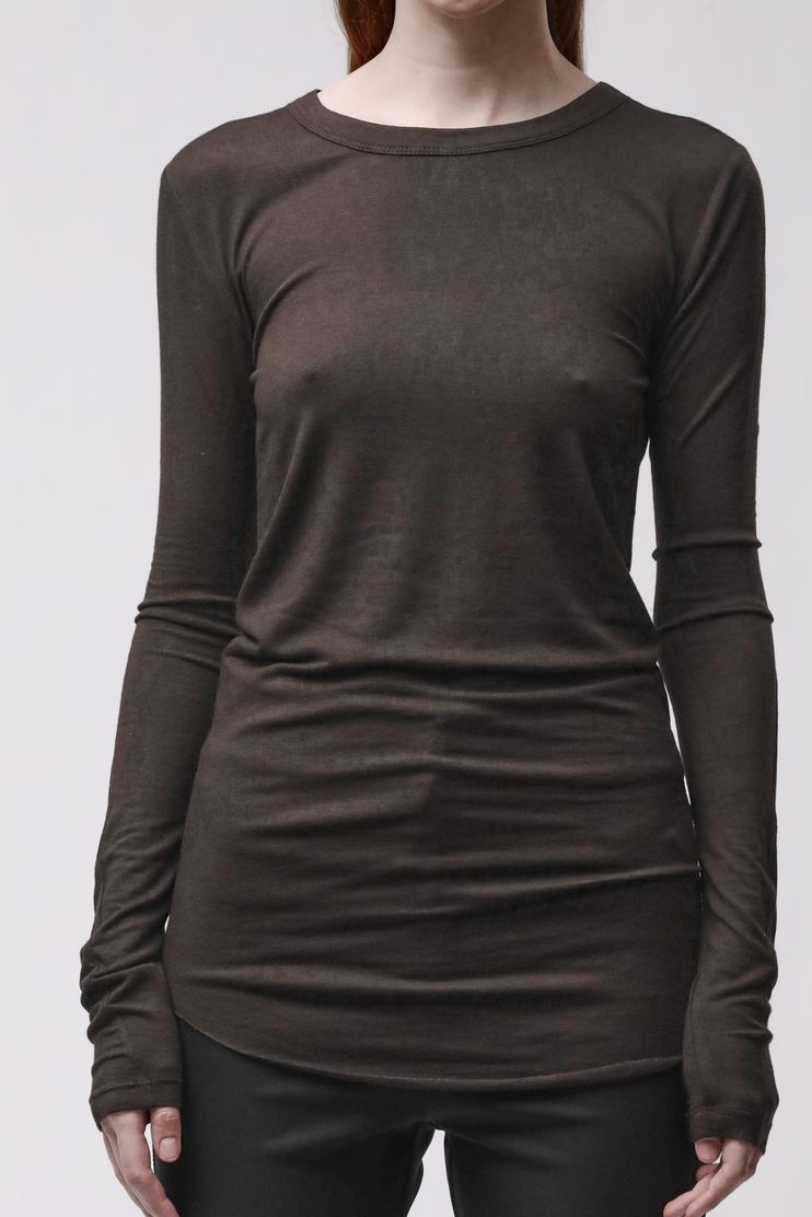Frau trägt oversized schwarzes Langarm-Shirt und schwarze Leggings, seriöser Look.