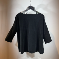 Schwarzes oversized Langarm-Shirt auf Bügel hängend.