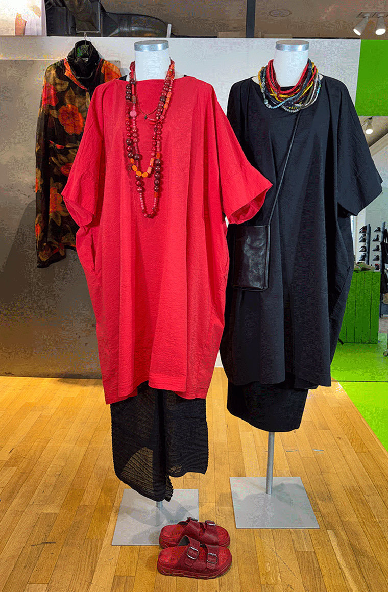 Zwei elegante Kimonos in Rot und Schwarz mit Accessoires auf Mannequins ausgestellt.