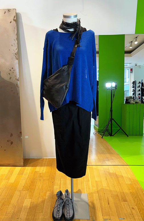 Modell auf Mannequin: blaues Langarm-Shirt, schwarzer langer Rock, Tasche und Schuhe.