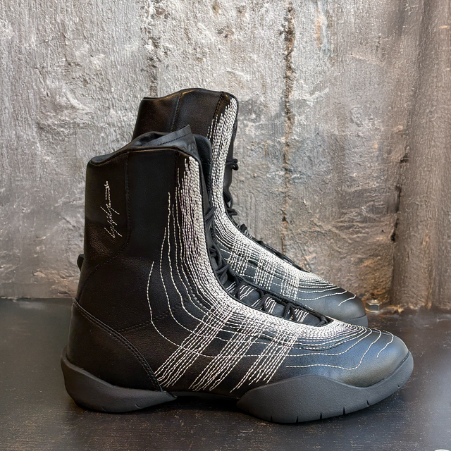 Schwarze Adidas-High-Tops mit silbernen Stichelementen und weichem Sohlenprofil.