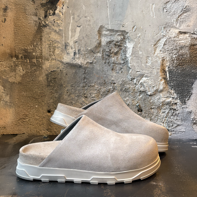 Bequeme graue Sneaker mit weichem Obermaterial und schwarzem Sohlenrand auf dunklem Untergrund.