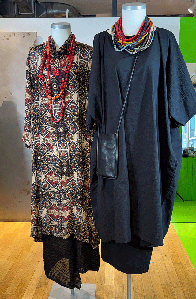 Zwei elegante Kleider mit Schal auf Mannequins ausgestellt.